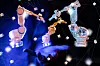 Digital industrial robot arms floating above an outstretched hand against a networked background