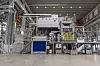 Large industrial aluminium casting machine inside Volvo factory hall.