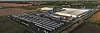 Aerial view of a large Mercedes-Benz truck and bus plant with rows of vehicles and warehouses.