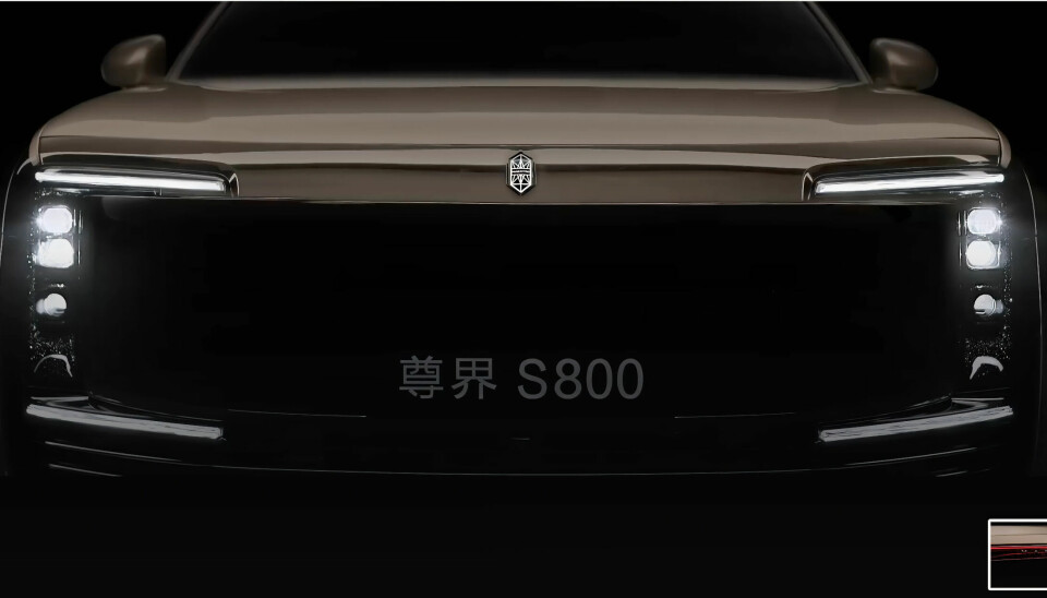 Front view of a black Maextro S800 car with headlights on in a dark studio.