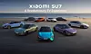Several Xiaomi SU7 electric cars parked in a line beside the sea.