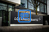 A Lockheed Martin and GM sign stands outside a glass-fronted office building.