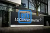 A Lockheed Martin and GM sign stands outside a glass-fronted office building.