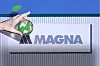A Magna sign mounted on a corrugated building wall, with a graphic hand holding a green globe.