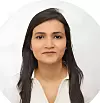 Studio headshot of a woman with long dark hair against a light background.