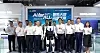 Group of people standing with two humanoid robots in front of a blue Shanghai Electric exhibition backdrop.