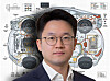 Portrait of a man in glasses in front of an electric vehicle wiring schematic.
