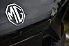 Close-up of an MG logo on the front of a black car.