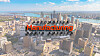 Aerial view of downtown Detroit skyline under a blue sky, with an Automotive Manufacturing North America logo over the city.